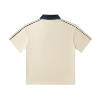 Beige short-sleeved polo shirt with a dark blue collar and black trim along the shoulders and sleeves, viewed from the back.